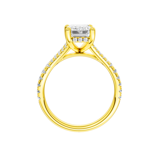 A profile view of the Emerald cut diamond engagement ring in 14k yellow gold with a prong diamond band and hidden halo setting