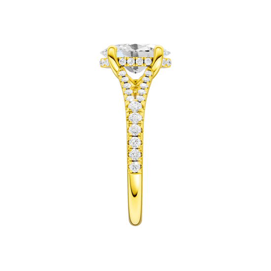 A side view of the Oval cut diamond engagement ring in 14k yellow gold with a prong band and hidden halo setting