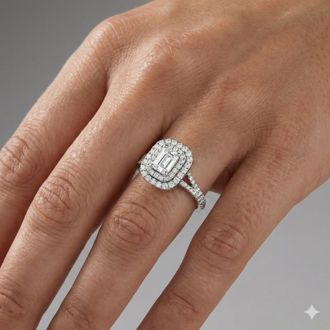 Emerald cut diamond engagement ring in 14k white gold with a prong diamond band and split setting on a hand