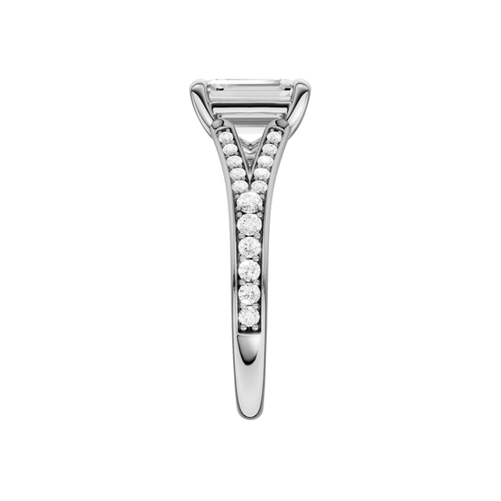 A side view of the Emerald cut diamond engagement ring in 14k white gold with a diamond channel band and split setting
