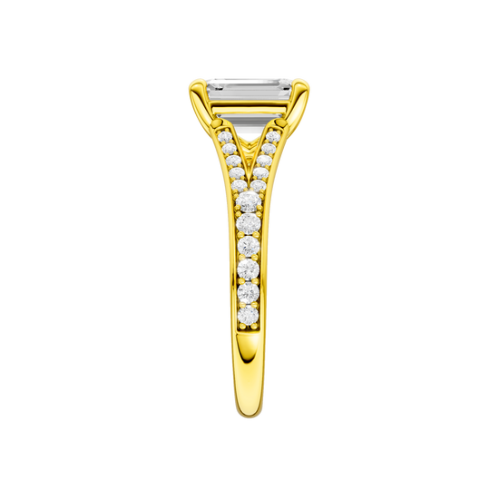 A side view of the Emerald cut diamond engagement ring in 14k yellow gold with a diamond channel band and split setting