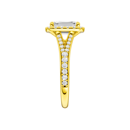 A side view of the Emerald cut diamond engagement ring in 14k yellow gold with a diamond channel band and split setting