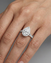 Pear cut diamond engagement ring in 14k white gold with a diamond channel band and split setting on a hand