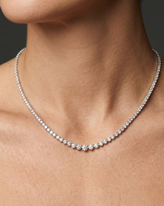 Lifestyle view of a model wearing a luxurious white gold or platinum graduated diamond tennis necklace featuring brilliant round-cut diamonds.
