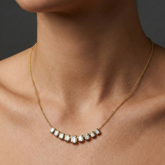 Yellow gold smaller emerald-cut diamond necklace worn on figure, offering a warm glow and effortlessly minimal sophistication.