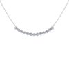 Up close front view of a white gold necklace featuring round white diamonds set along a gently curved design on a delicate chain.