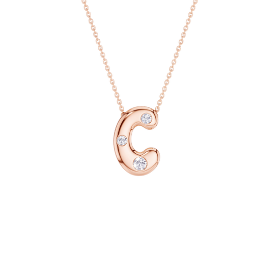 A rose gold letter 'C' pendant necklace with three small clear gemstones, suspended from a delicate matching chain against a solid white background.