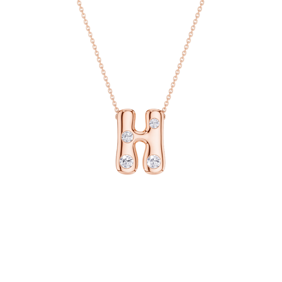 A rose gold initial necklace featuring the letter 'H' adorned with three clear round-cut gemstones, suspended from a delicate matching chain against a solid white background.
