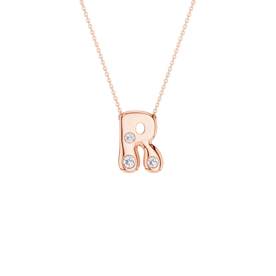 A rose gold initial necklace featuring the letter 'R' adorned with three small clear round-cut gemstones, suspended from a delicate matching chain against a solid white background.