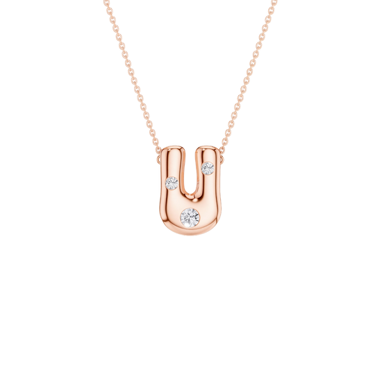 A rose gold U-shaped pendant necklace with three small clear gemstones, suspended from a delicate matching chain on a solid white background.