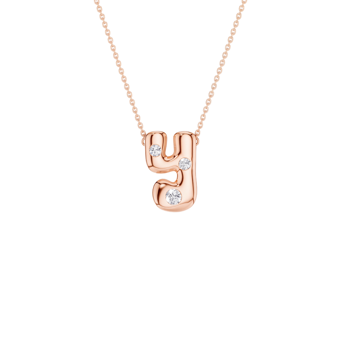 A rose gold initial necklace featuring the letter 'y' adorned with three small clear round-cut gemstones, suspended from a delicate matching chain against a solid white background.