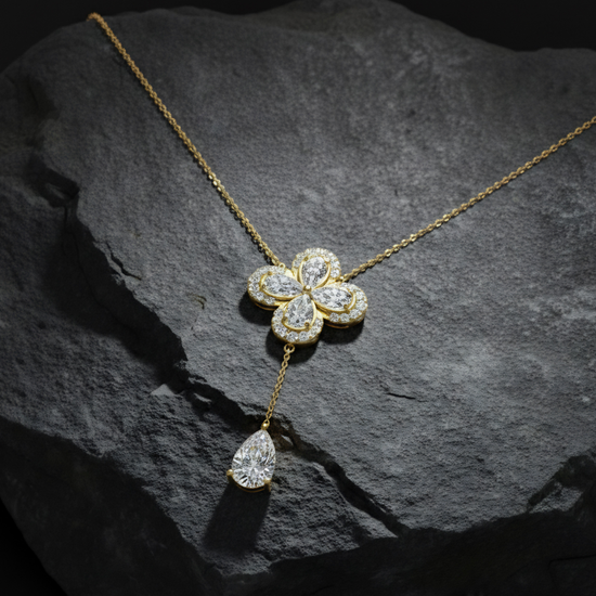Front view of a yellow gold floral diamond necklace featuring a pear-cut diamond flower pendant with matching diamond accents along a delicate yellow gold chain.