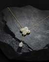 Front view of a yellow gold floral diamond necklace featuring a pear-cut diamond flower pendant with matching diamond accents along a delicate yellow gold chain.