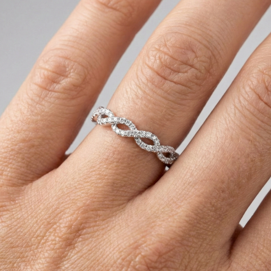 A top-down view of a 14K white gold braided ring with a continuous pavé diamond design on hand.