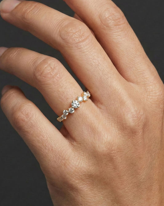 A top-down view of a 14K yellow gold ring with a five-stone cluster of alternating marquise and round diamonds on hand.