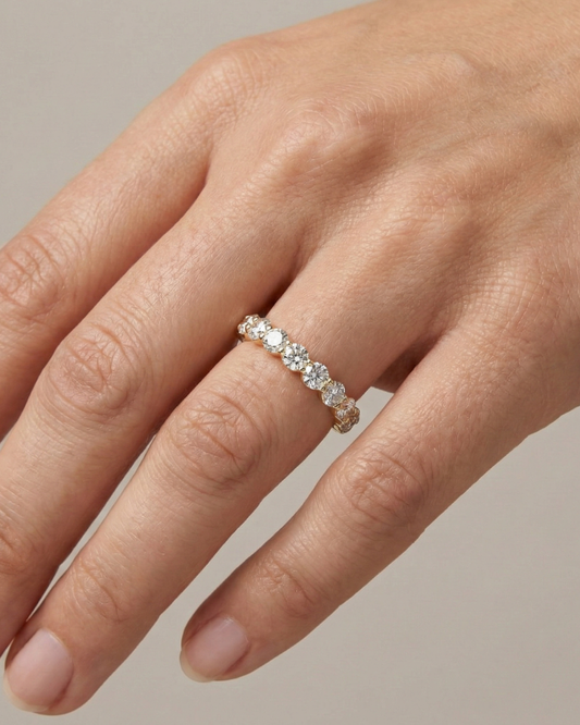 On hand luxurious 14k yellow gold 2/3 eternity wedding band featuring 1.5 total carats of graduated round-cut lab-grown diamonds.