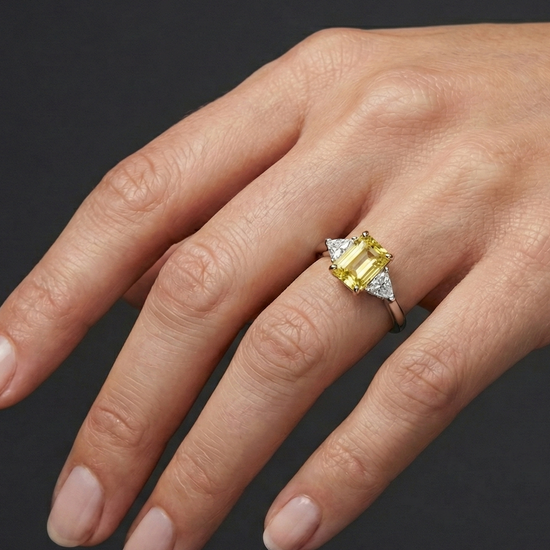 2.91 cttw Soleil Radiant-Cut Three-Stone Diamond Ring on hand. Featuring a 2.50ct IGI Certified Vivid Canary center and Trillion-Cut E-F/VS+ side stones in Solid 14K Gold with Insured Free Shipping.