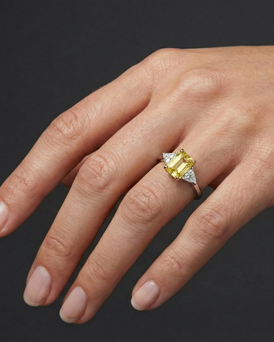 2.91 cttw Soleil Radiant-Cut Three-Stone Diamond Ring on hand. Featuring a 2.50ct IGI Certified Vivid Canary center and Trillion-Cut E-F/VS+ side stones in Solid 14K Gold with Insured Free Shipping.