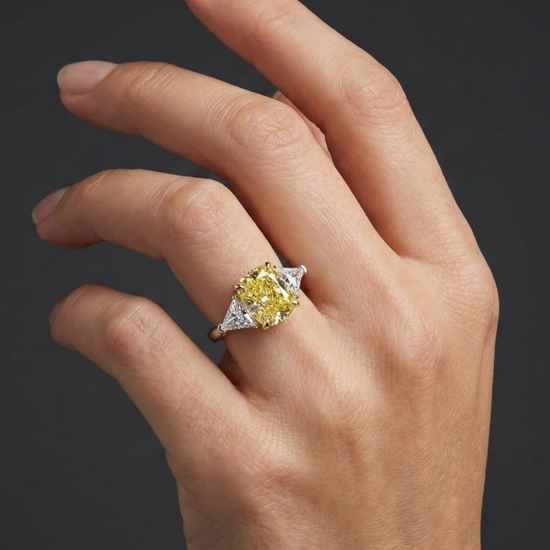 Lifestyle angled view of 4.66 Cttw Soleil Elongated Cushion Canary Yellow & White Trilogy Engagement Ring with IGI Certified 4.0ct  VS+ Vivid center lab grown diamond and .66 cttw of VS+ E-F diamond triangle side stones.