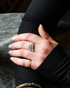 An on finger view of a 14K white gold open-shank ring with a continuous spiral design and a pavé diamond surface