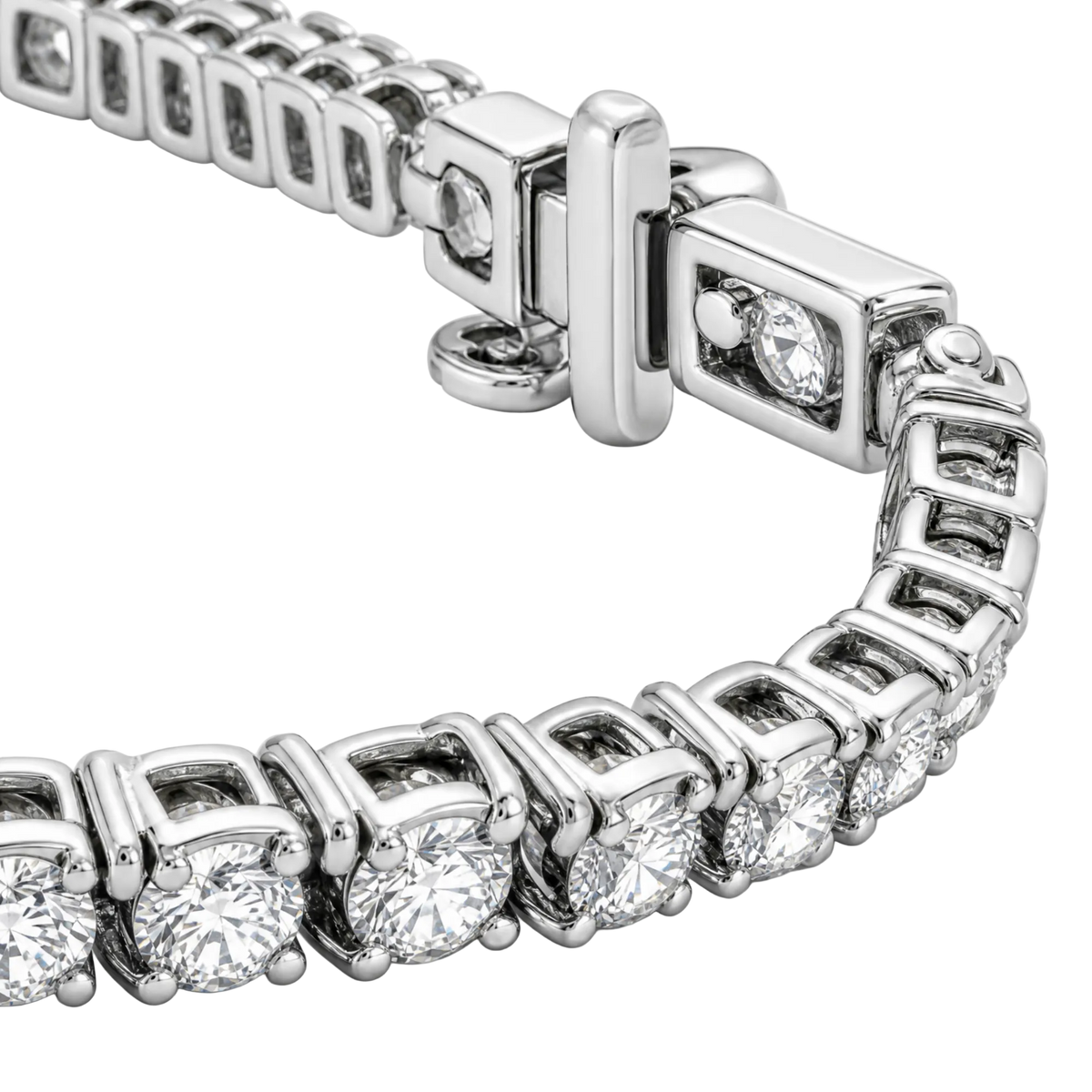 A close-up of a silver tennis bracelet with round-cut clear stones in a box setting and a polished clasp, photographed on a white background.