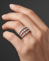 A close-up of a hand wearing a silver-toned ring with a double row of sparkling clear gemstones in a diamond-like pattern, set against a dark gray background.