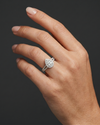 A hyper-realistic close-up of a woman's elegantly posed hand wearing a sparkling, pear-shaped diamond engagement ring. The ring features a diamond halo and a diamond-encrusted split shank, scaled proportionally to sit naturally on her ring finger. The photograph is shot in a luxury editorial style with soft, diffused lighting that highlights both the natural skin texture and the brilliant details of the jewelry, all set against a smooth, dark charcoal gray background.
