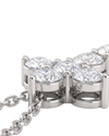 Extreme close-up of the base of a white gold diamond cross pendant, showcasing the intricate metal basket setting beneath the sparkling stones and the attached chain.