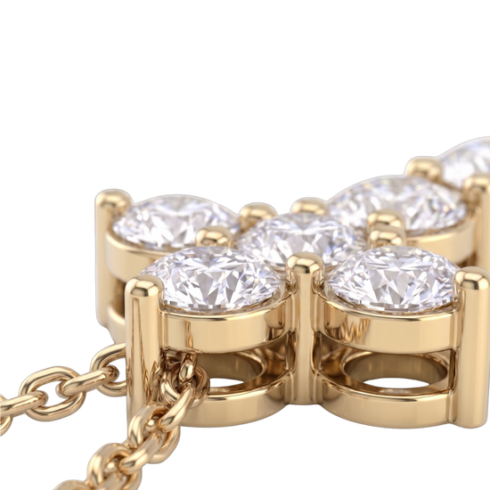 Extreme close-up of the base of a yellow gold diamond cross pendant, showcasing the intricate metal basket setting beneath the sparkling stones and the attached chain.
