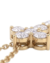 Extreme close-up of the base of a yellow gold diamond cross pendant, showcasing the intricate metal basket setting beneath the sparkling stones and the attached chain.